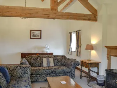 a living room with a couch and a table at Skimblescott Barn in Monkhopton