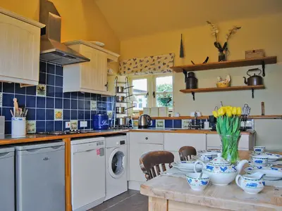 a kitchen with a table with a washing machine at St Vincent in Plaish