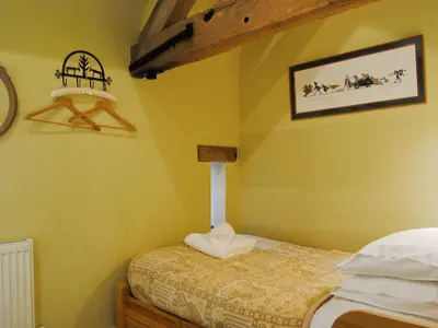 a small bedroom with a bed with yellow walls at St Vincent in Plaish