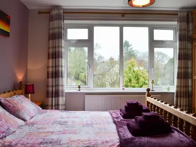 a bedroom with a large bed and a window at Dinhope Big Barn in Craven Arms