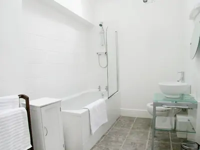 a white bathroom with a tub and a sink at Cow Shed in Farden