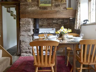 a dining room with a wooden table and chairs at Titchbourne Cottage in Clee Saint Margaret