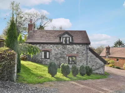 an old stone house on a green lawn at Angel Barn in Farden