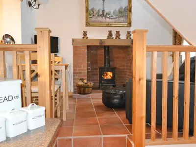 a living room with a fireplace and a staircase at Angel Barn in Farden