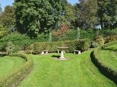 a garden with a fountain in the middle of the grass at Angel Barn in Farden
