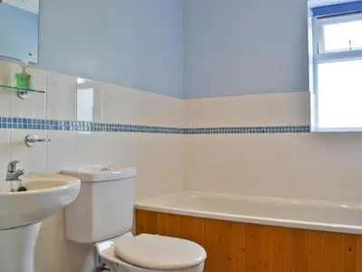 a bathroom with a toilet and a sink and a tub at Honeysuckle Cottage in Minsterley