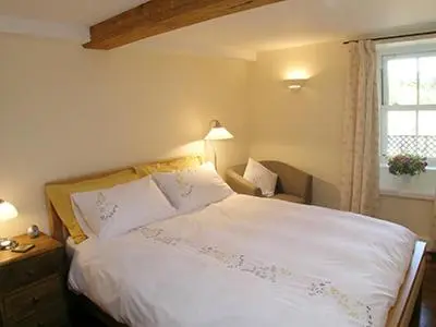 a bedroom with a white bed and a window at Mouse Castle Barn in Hay-on-Wye