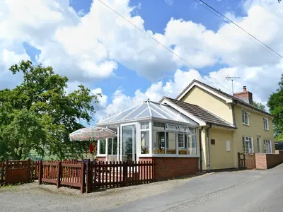 a house with a fence in front of it at Mavis Cottage in Kington