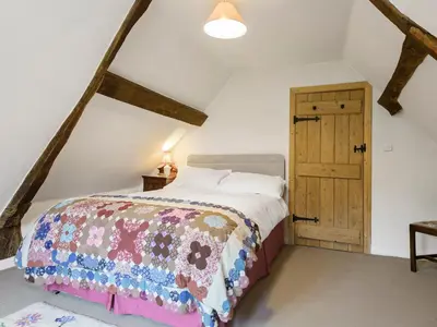 a bedroom with a bed and a wooden cabinet at Walnut Tree Cottage in Bucknell