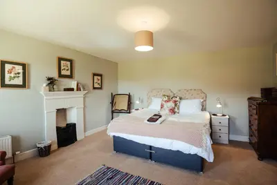 a bedroom with a large bed and a fireplace at Stone House Wales in Kington