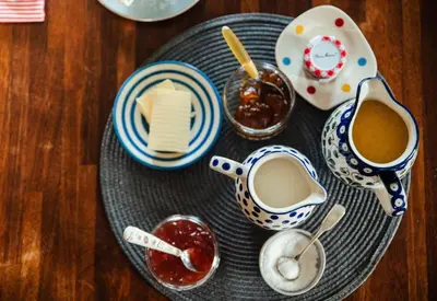 a plate of food with jam and a cup of coffee at Stone House Wales in Kington