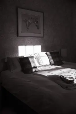 a black and white photo of a bed in a bedroom at Stone House Wales in Kington