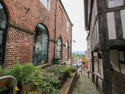 an alley in an old brick building with plants at The Larches in Bishops Castle