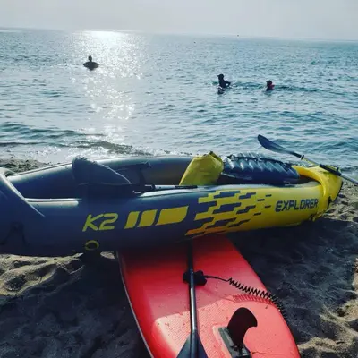 a kayak on the beach with people in the water at Ideal rural location for beaches, hills and town in Bow Street
