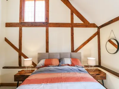 a bedroom with a bed with wooden beams at Awelfan in Newtown