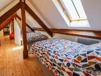 a attic bedroom with a bed and a window at Awelfan in Newtown