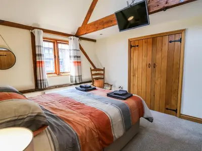 a bedroom with a bed and a tv on the wall at Awelfan in Newtown