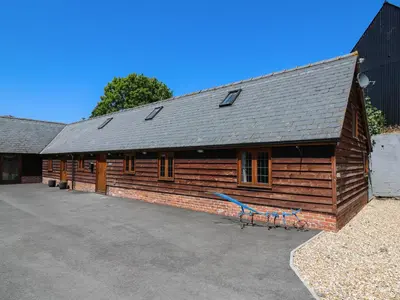 a wooden barn with a blue bench in front of it at Awelfan in Newtown