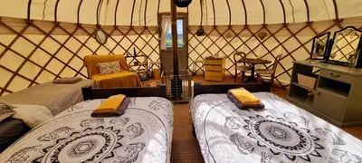 a room with two beds in a yurt at Bronfelen Yurt in Cynghordy