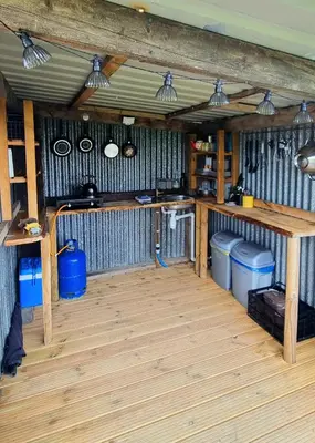 a kitchen with a table and some pots and pans at Bronfelen Yurt in Cynghordy