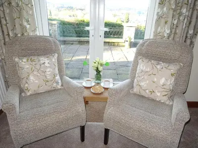 two chairs and a coffee table in a living room at Glan Wye in Rhayader