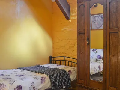 a small room with a bed and a wooden cabinet at The Bailey in Glasbury