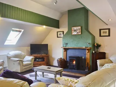 a living room with a couch and a fireplace at The Bailey in Glasbury