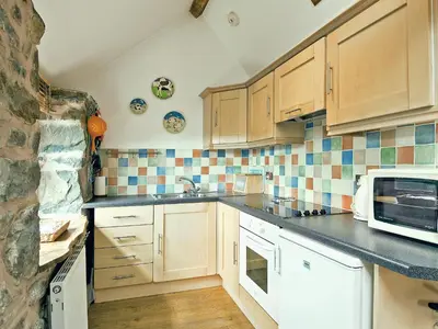 a kitchen with a sink and a microwave at Llofft Stabal in Llanerfyl