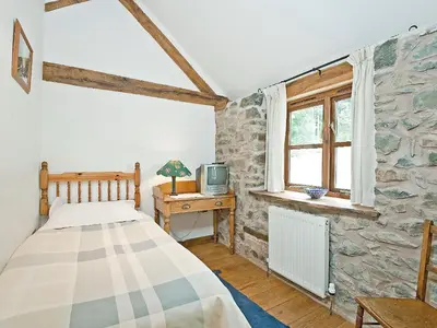a bedroom with a bed and a tv on a table at Llofft Stabal in Llanerfyl