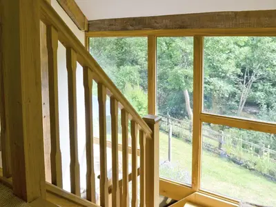 a staircase in a house with a large window at Ty Rhyd in Llanrhaeadr-ym-Mochnant