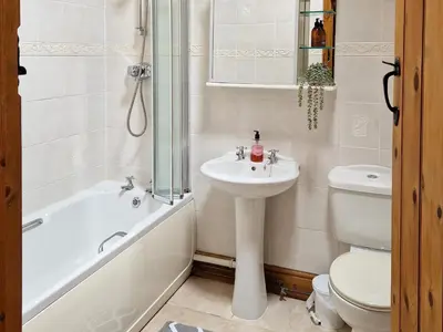 a bathroom with a sink and a toilet and a bath tub at Y Dderwen At Brynglas Farm in Llanfair Caereinion