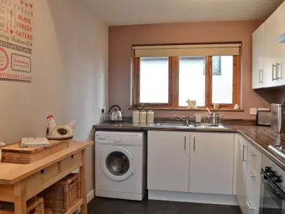 a kitchen with a washing machine and a sink at Panteg Cottage in Cross Inn