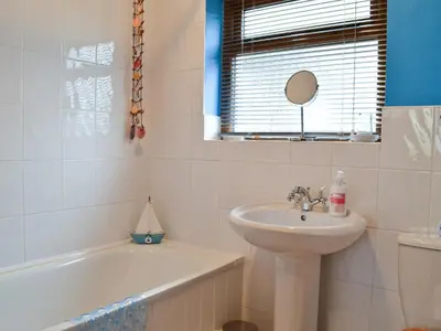 a bathroom with a sink and a bath tub and a sink at Panteg Cottage in Cross Inn