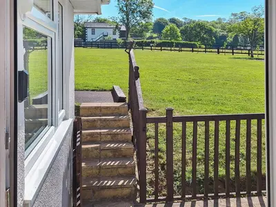 a porch with a wooden railing and a bench at Bwthyn Gwyn in Ciliau-Aeron