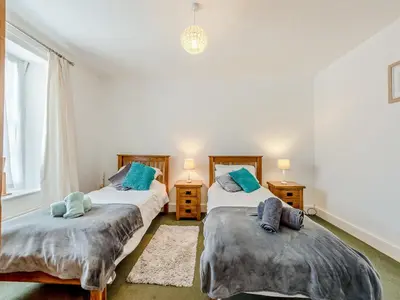 two twin beds in a room with two lamps at Glendower in Aberaeron