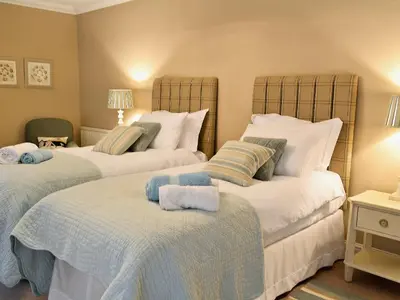 a bedroom with two beds with white sheets at Awelfa - On7 in Aberaeron