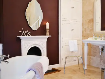 a bathroom with a white tub and a fireplace at Awelfa - On7 in Aberaeron