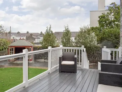 a wooden deck with a chair on top of it at Awelfa - On7 in Aberaeron