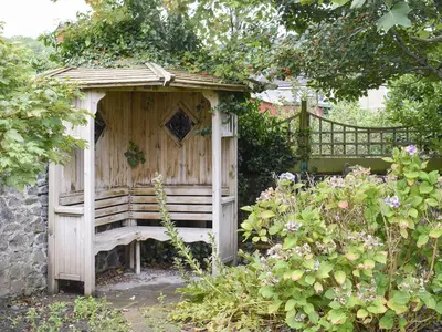a wooden outhouse in the middle of a garden at Awelfa - On7 in Aberaeron