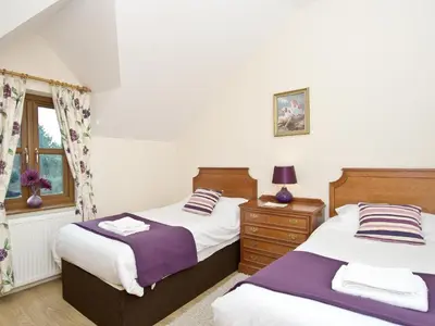a bedroom with two beds and a window at Magnolia Cottage in Aberaeron
