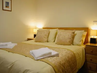 a bedroom with a bed with two towels on it at Llechwedd Mawr in Scyborycoed