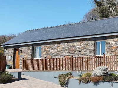 a stone house with a bench in front of it at Beudy-Oh2 in Dihewid