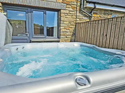 a jacuzzi tub in front of a building at Cartws-Oh3 in Dihewid