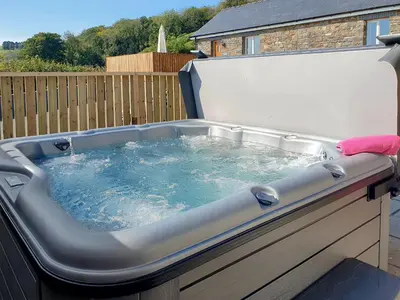 a hot tub with water in it in a backyard at Cartws-Oh3 in Dihewid