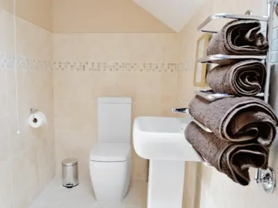 a bathroom with a sink and a toilet and towels at Stabl-Oh4 in Dihewid