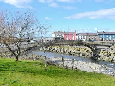 a bridge over a river in a city at Beudy Bach-Oh5 in Dihewid