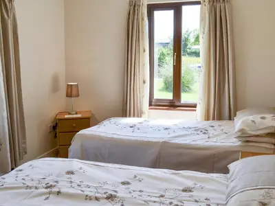 two beds in a room with a window at Bryneirin in Tal-gareg