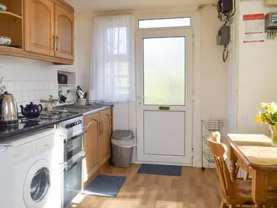 a kitchen with a washer and dryer and a table at Tynlon Villa in Bronant