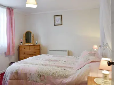 a bedroom with a bed and a dresser and a mirror at Tynlon Villa in Bronant