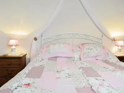 a bed with pink and white sheets and pillows at Tynlon Villa in Bronant
